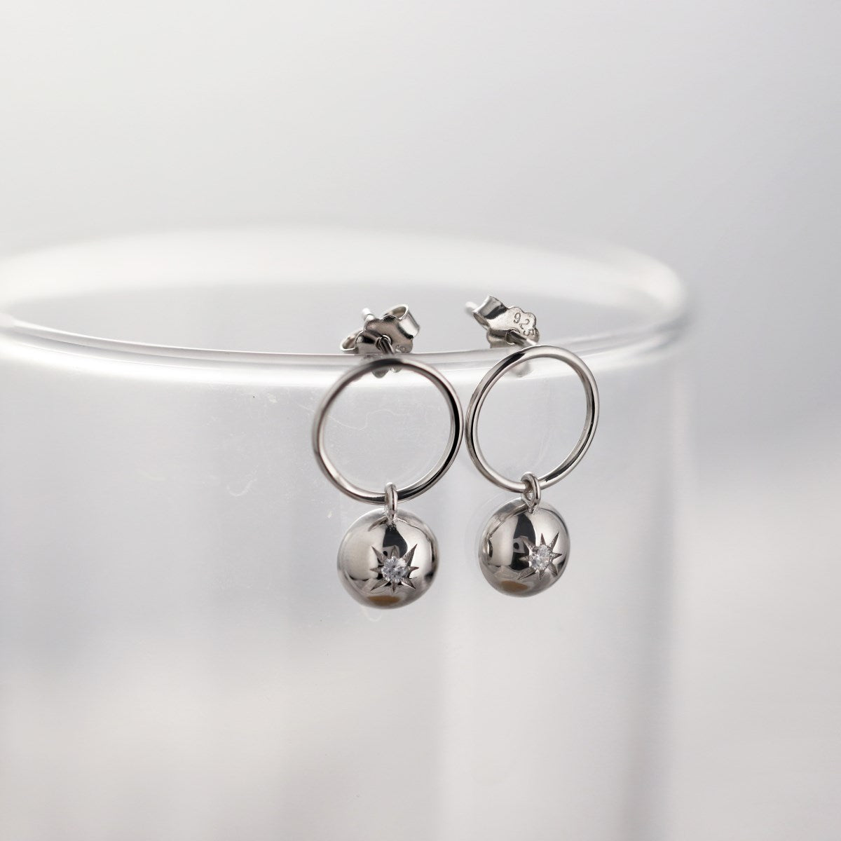Sterling silver earrings with star embossing and zirconia stone